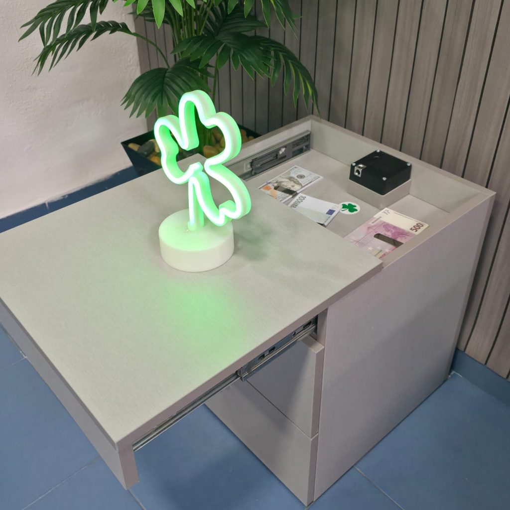 Escritorio gris con compartimento oculto abierto y trébol luminoso decorativo